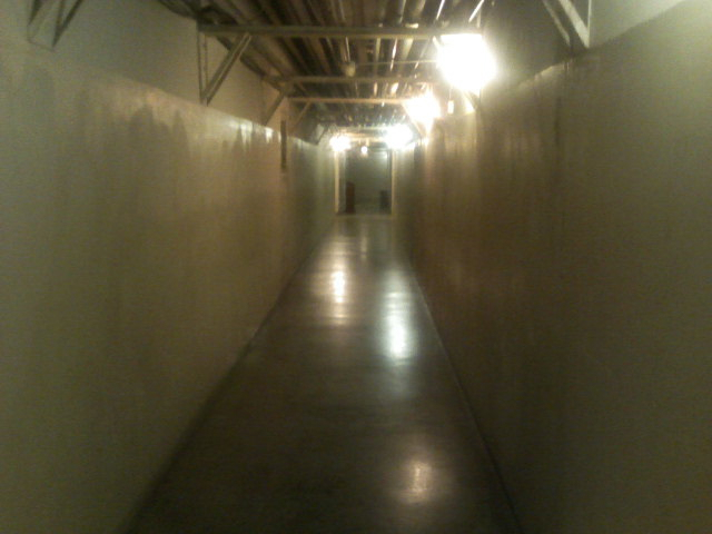 This is the corridor that starts at the right of the bottom of the stairs.  Throw in some flickering lights, a few red warning strobes, and you have yourself a good video game level.